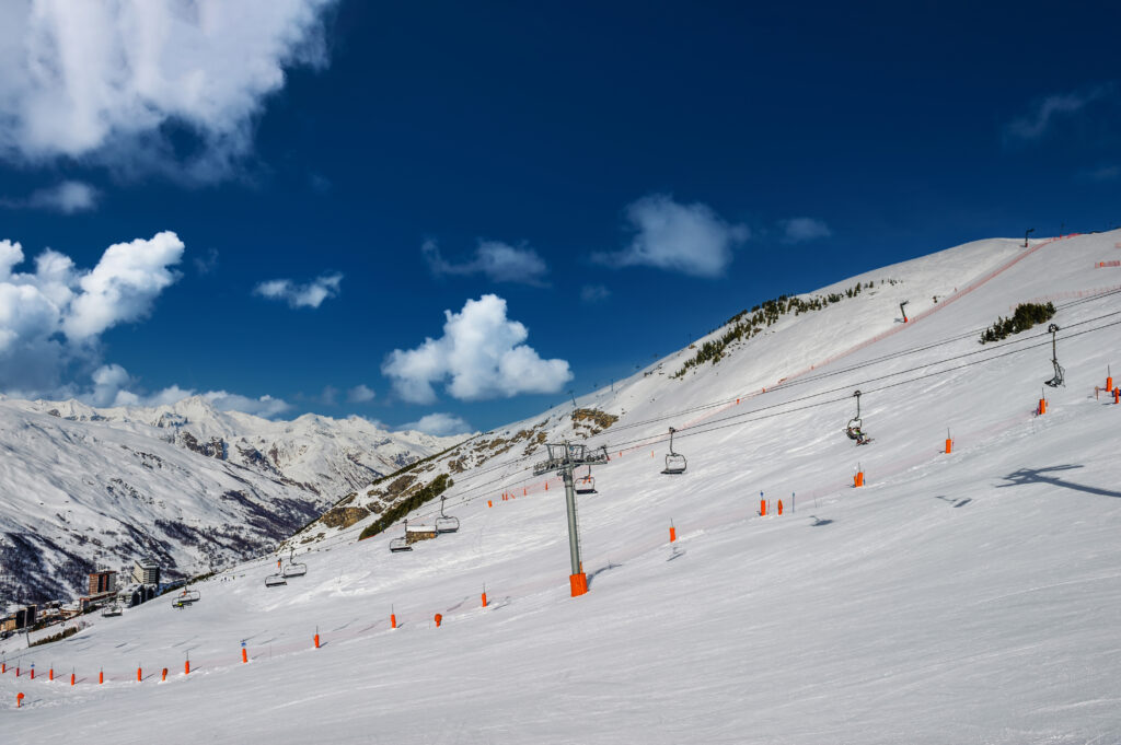 Alpine winter mountain landscape. French Alps covered with snow in sunny day. Meribel, France.